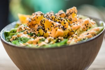 Die fertige Poke Bowl: Eine Mischung aus Lachs, Mango, Seealgen und Avocado, bestreut mit schwarzem und weißem Sesam.