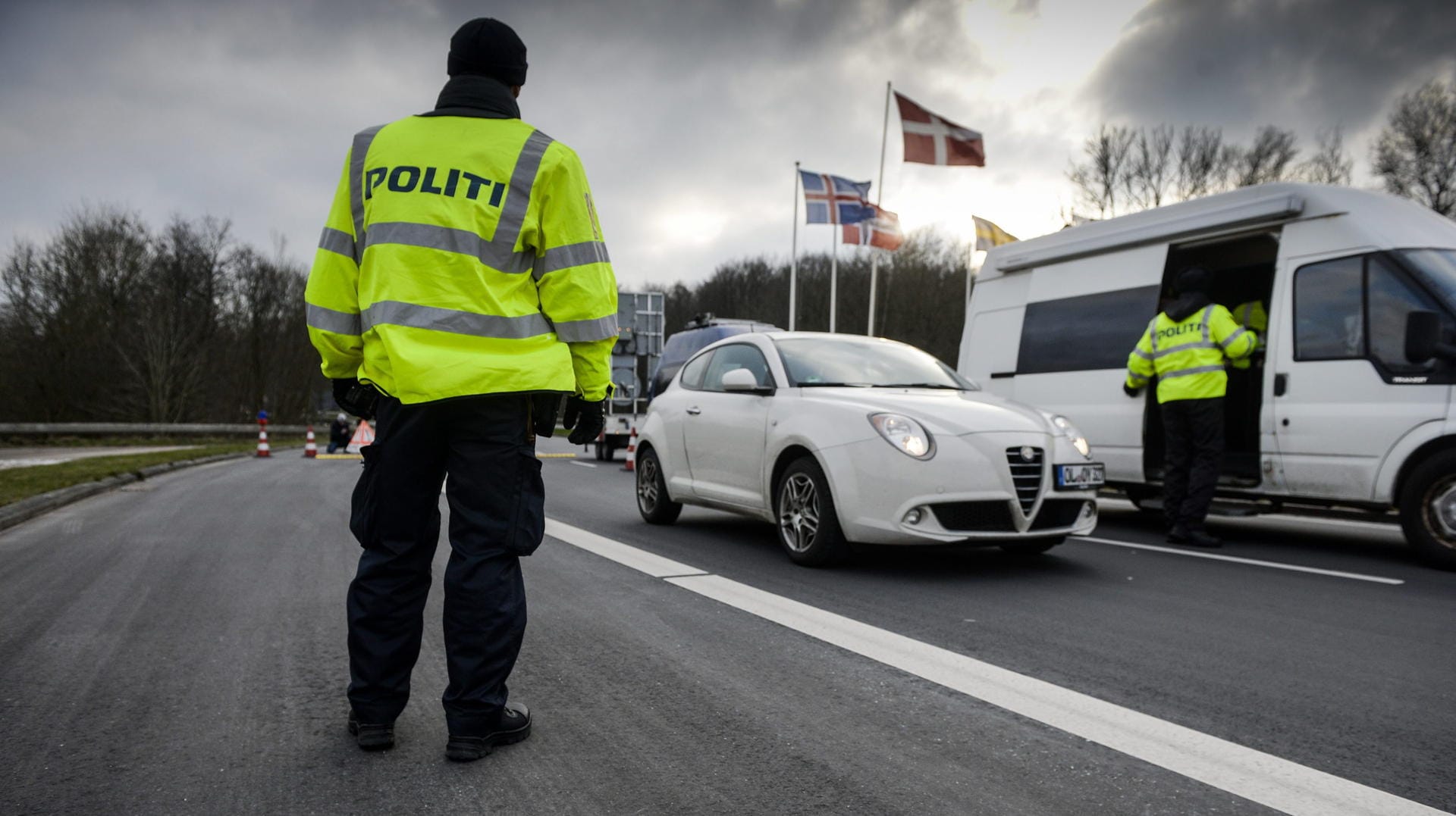 Dänische Polizisten kontrollieren Autos an der deutschen Grenze.