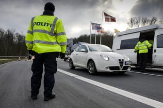 Dänische Polizisten kontrollieren Autos an der deutschen Grenze.