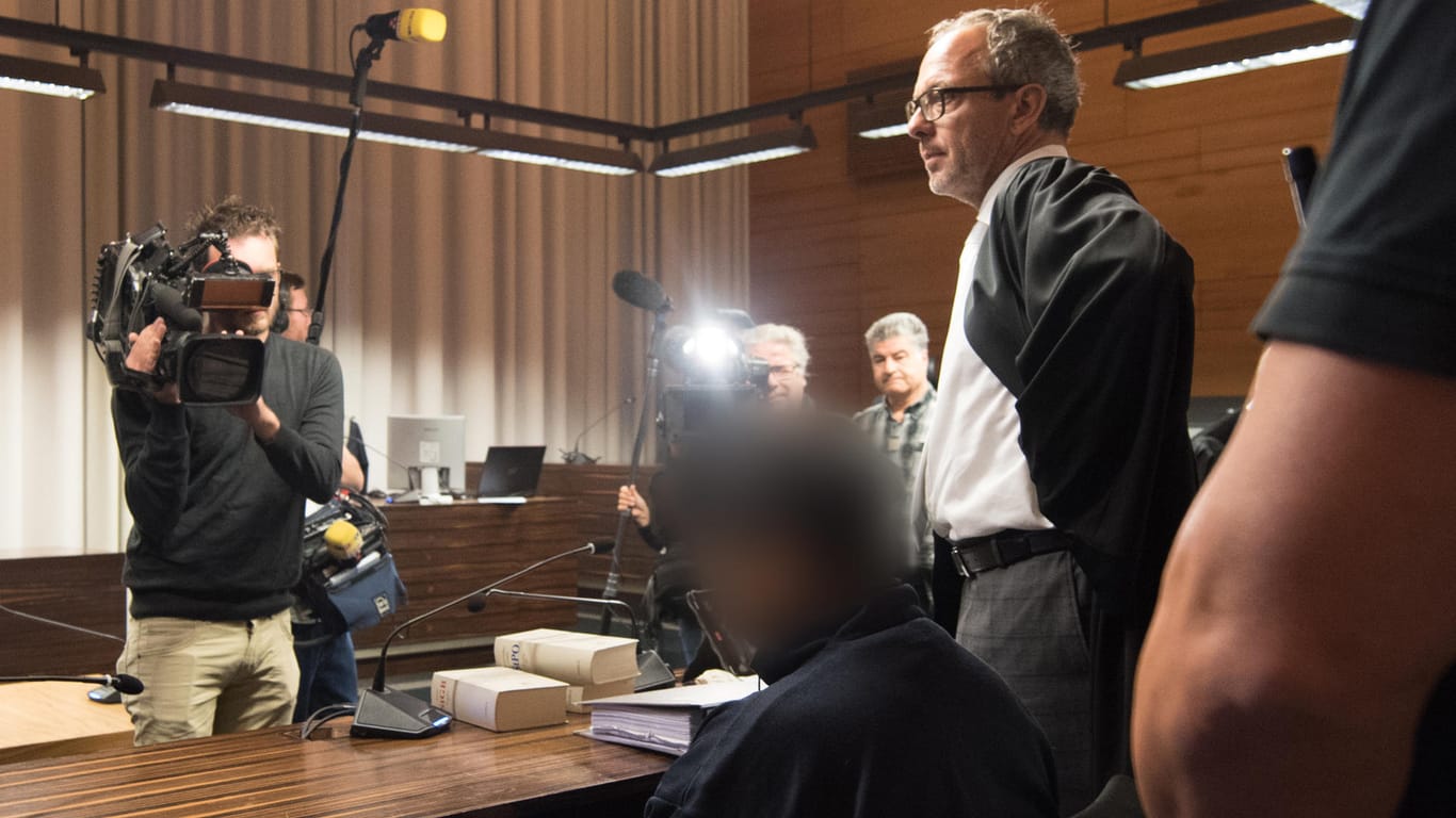 Der Angeklagte Hussein K. sitzt in Freiburg im Landgericht im Gerichtssaal neben seinem Verteidiger Sebastia Glathe (r).