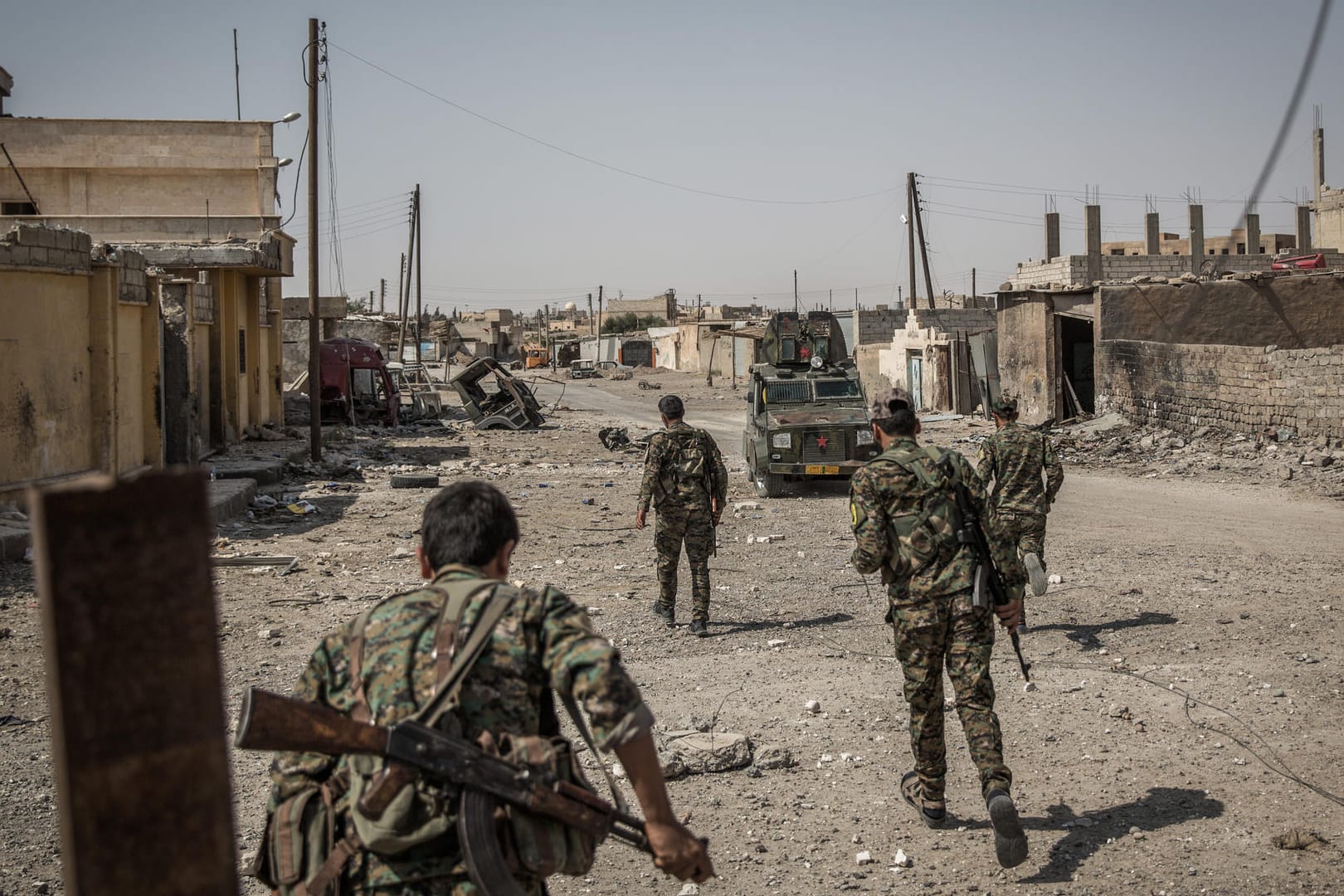 Soldaten der Syrischen Demokratischen Kräfte überqueren eine Straße in Al-Rakka (Syrien).