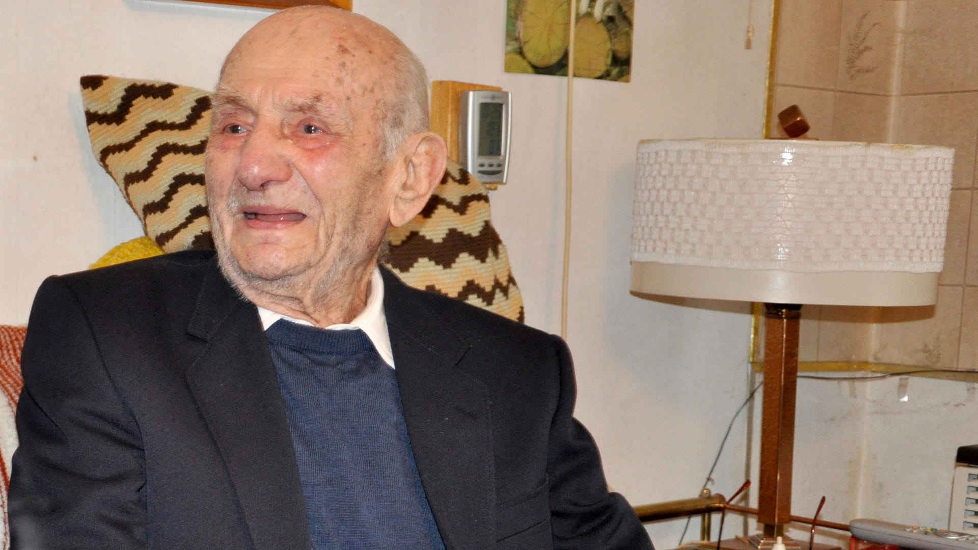 Gustav Gerneth sitzt an an einer gedeckten Kaffeetafel in seiner Wohnung in Havelberg.