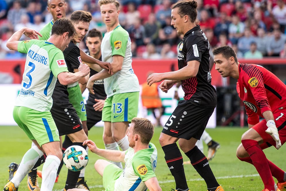 Wolfsburgs Paul Verhaegh (l.) und Maximilian Arnold (M.) kämpfen mit Leverkusens Lucas Alario (3. v. l.) um den Ball.