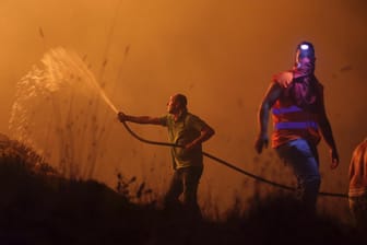 Freiwillige Helfer in Obidos (Portugal) versuchen mit Wasserschlauch zu löschen