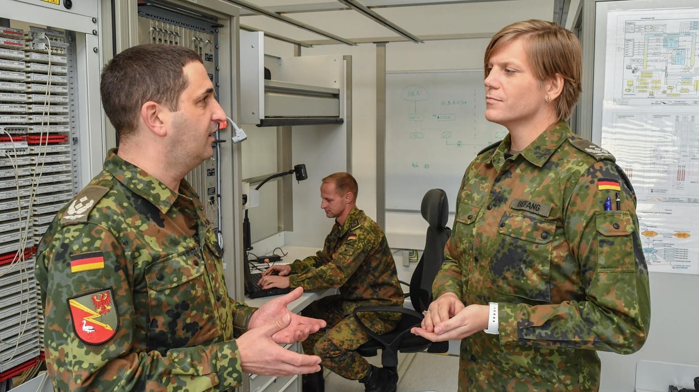 Oberstleutnant Anastasia Biefang (r) und ihr Vorgänger Oberstleutnant Thorsten Niemann, unterhalten sich in einem Lehrraum einer Ausbildungsanlage.