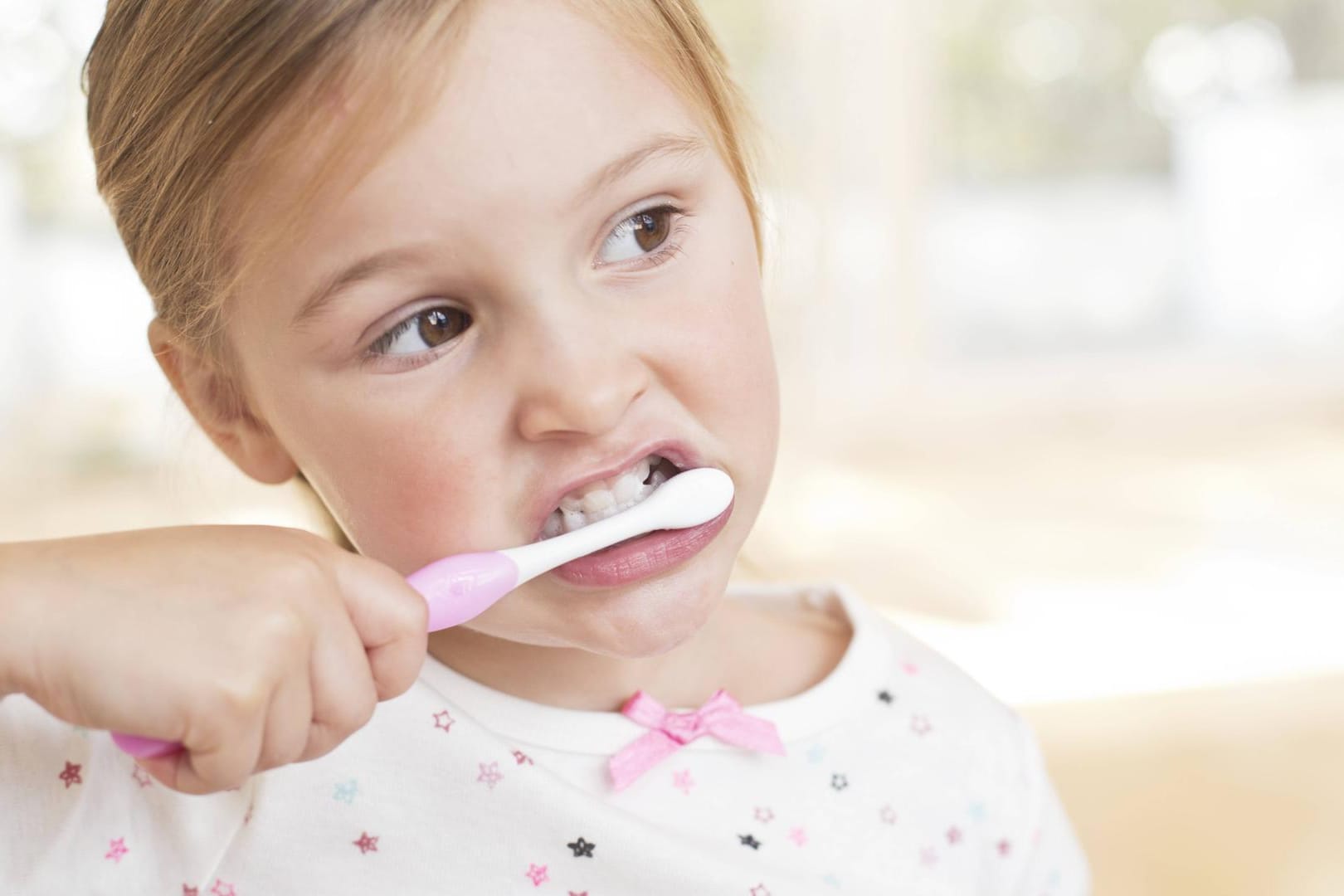 Ein Mädchen putzt seine Zähne: Eltern sollten ihre Kinder zur Hygiene motivieren.