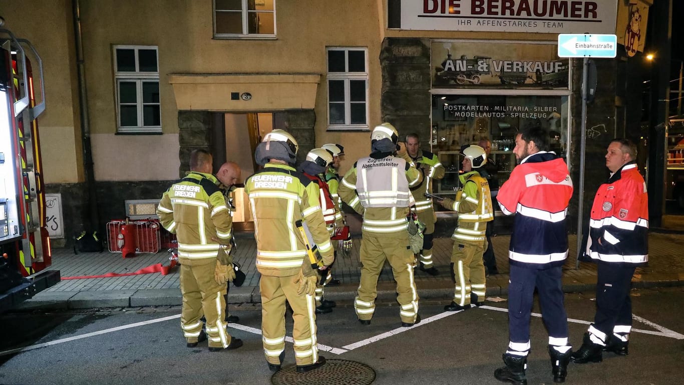Feuerwehrkräfte stehen in Dresden vor einem Wohnhaus, in dem es eine Explosion gegeben hat.