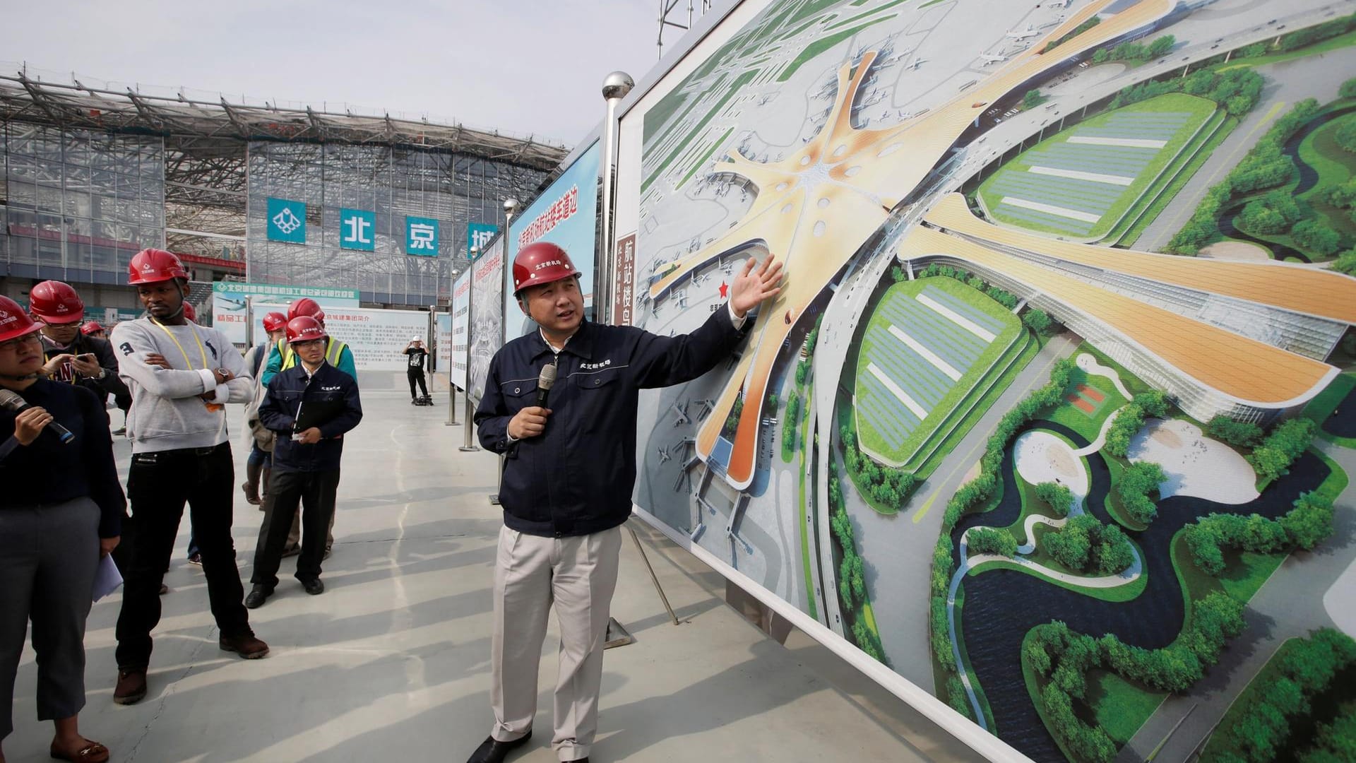 Ein Ingenieur erklärt Journalisten auf der Baustelle den neuen Super-Flughafen von Peking.