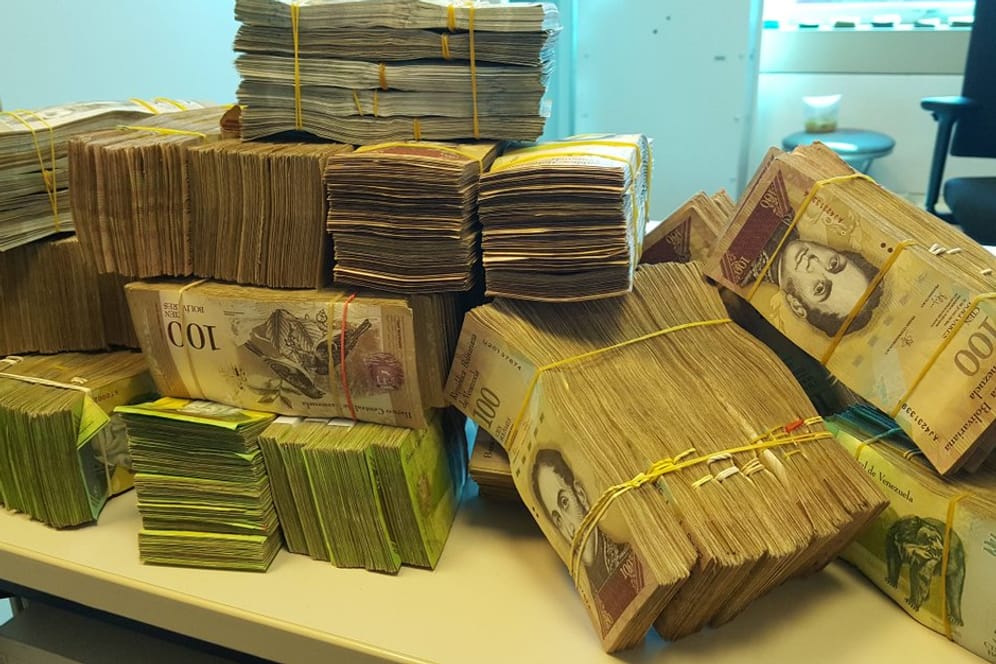 Wegen der hohen Inflation bezahlt man in Venezuela Pässe mit Stapeln von Geld.