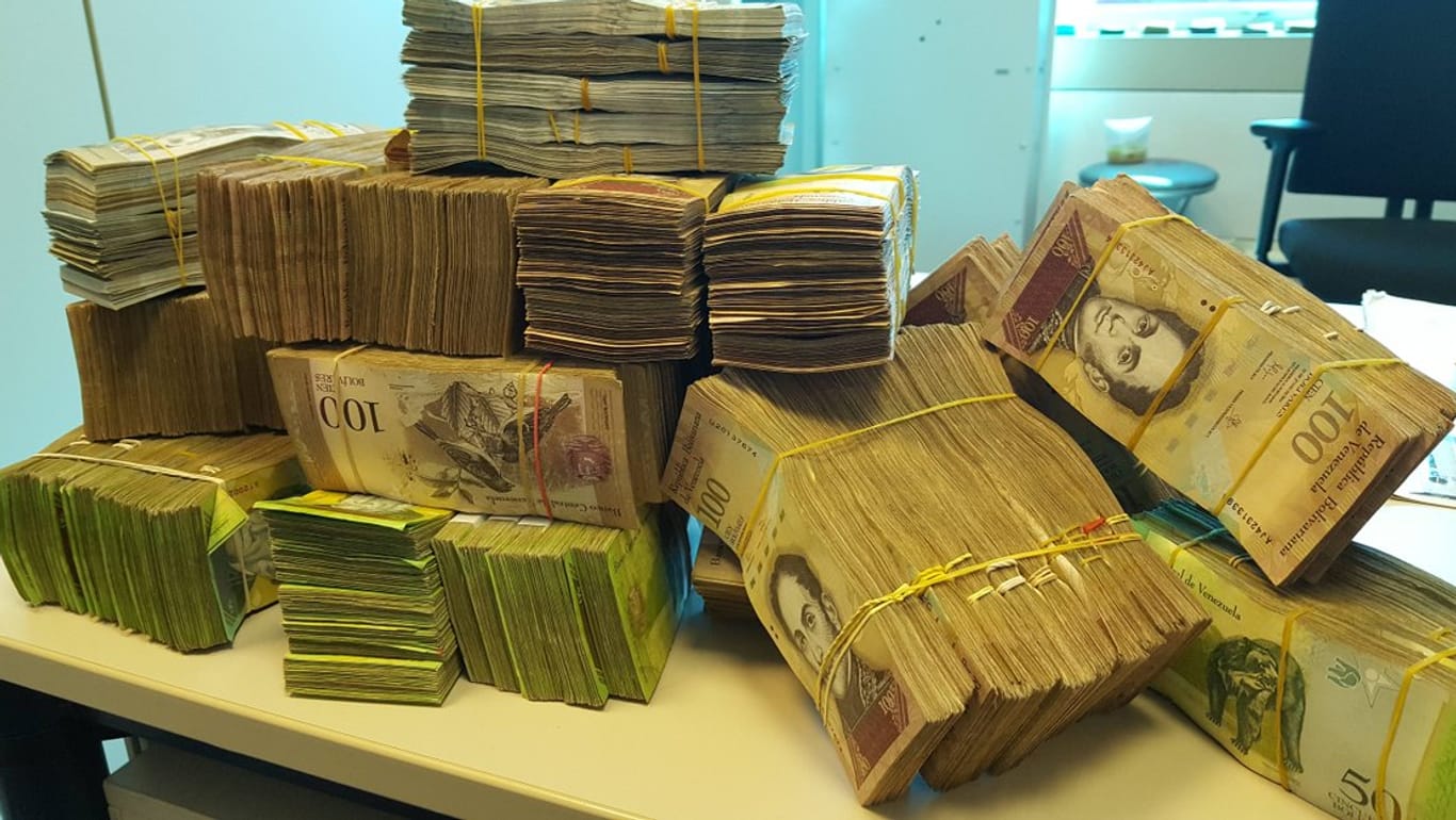 Wegen der hohen Inflation bezahlt man in Venezuela Pässe mit Stapeln von Geld.