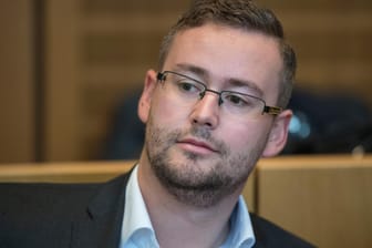 Der rheinland-pfälzische AfD-Spitzenkandidat Sebastian Münzenmaier sitzt auf der Anklagebank des Verhandlungssaales des Amtsgerichts in Mainz.
