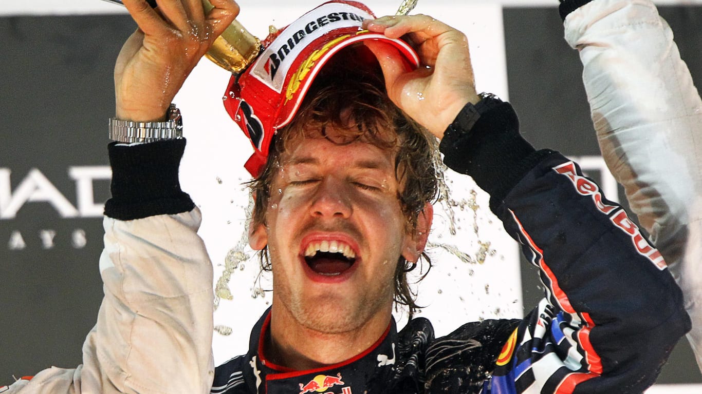 Sebastian Vettel genießt nach seinem ersten WM-Titel eine ausgiebige Champagner-Dusche.