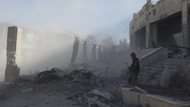 Ein Kämpfer der Syrischen Demokratischen Kräfte steht in den Ruinen von Al-Rakka. Ein Kämpfer der Syrischen Demokratischen Kräfte steht in den Ruinen von Al-Rakka.