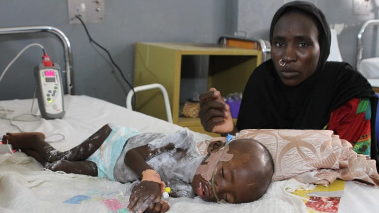 Fanna Maibula sitzt auf der Intensivstation für schwer unterernährte Kinder im Universitätsklinikum in Maiduguri (Nigeria) am Bett ihres 18 Monate alten Sohnes Babamadus.