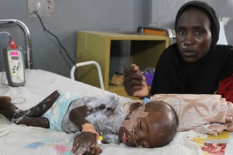 Fanna Maibula sitzt auf der Intensivstation für schwer unterernährte Kinder im Universitätsklinikum in Maiduguri (Nigeria) am Bett ihres 18 Monate alten Sohnes Babamadus.