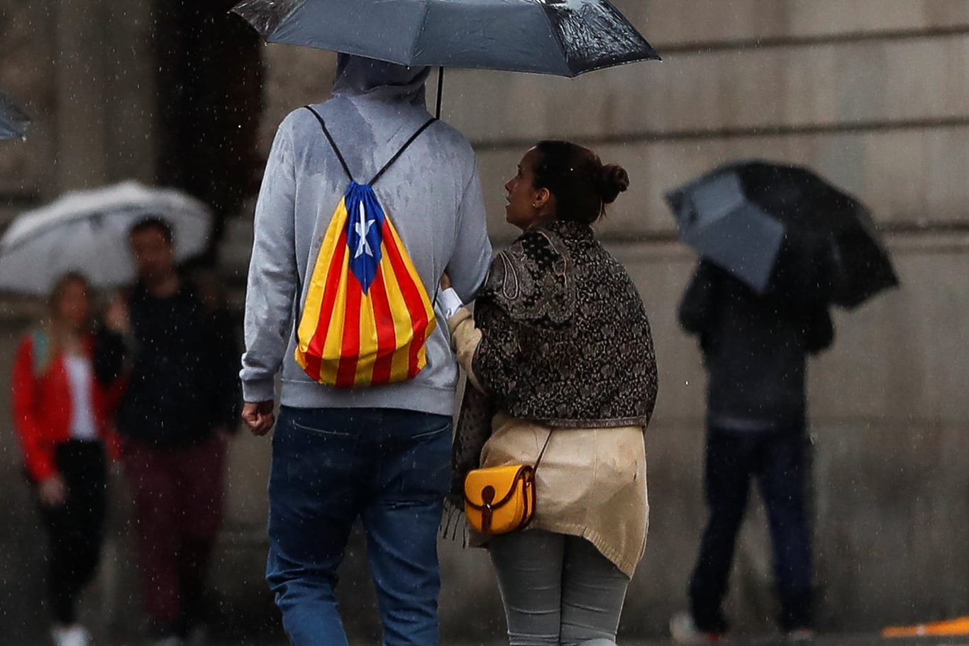 Trübe Aussichten in Barcelona: Ein Mann mit einem Rucksack in den Farben der katalanischen Separatisten läuft durch den Regen.