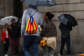 Trübe Aussichten in Barcelona: Ein Mann mit einem Rucksack in den Farben der katalanischen Separatisten läuft durch den Regen.