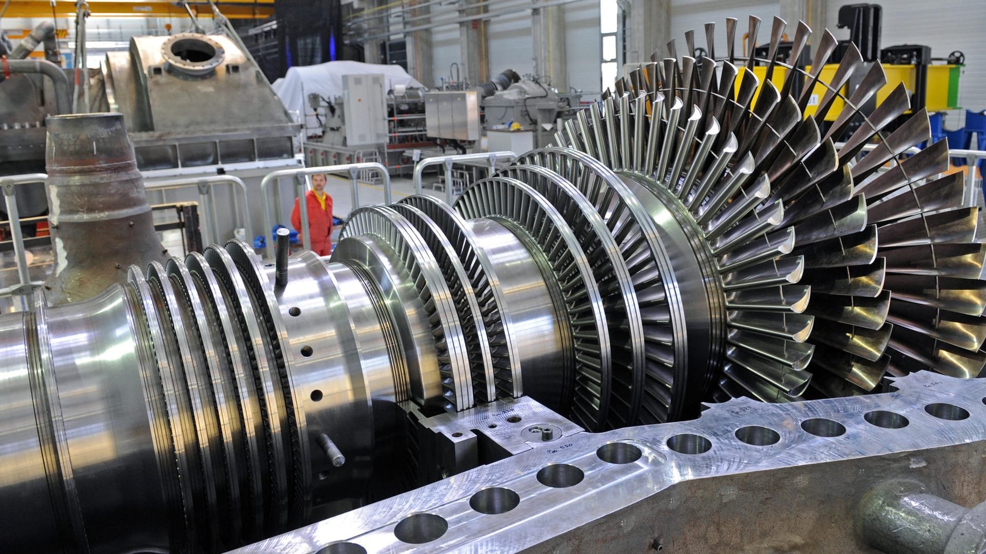 Ein Monteur im Görlitzer Dampfturbinenwerk von Siemens neben einem Rotorin in der Montagehalle