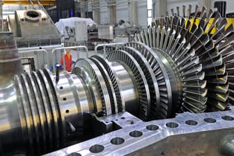 Ein Monteur im Görlitzer Dampfturbinenwerk von Siemens neben einem Rotorin in der Montagehalle
