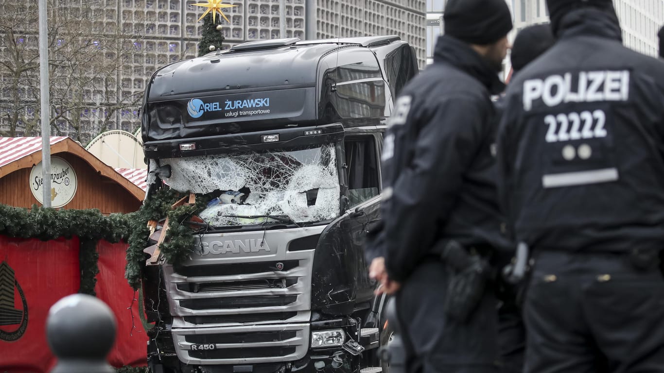 Polizisten stehen vor dem zerstörten LKW am Breitscheidplatz in Berlin.
