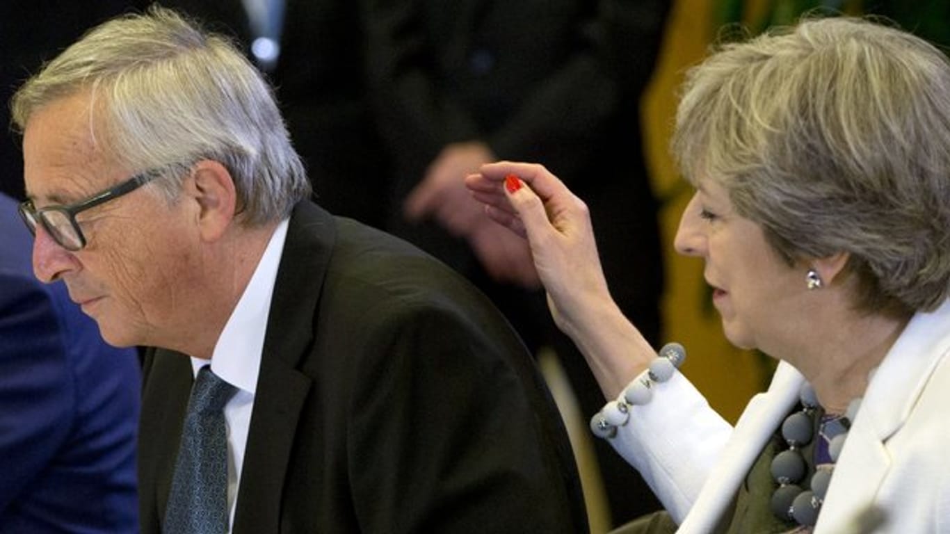 Die britische Premierministerin Theresa May sitzt neben EU-Kommissionspräsident Jean-Claude Juncker.