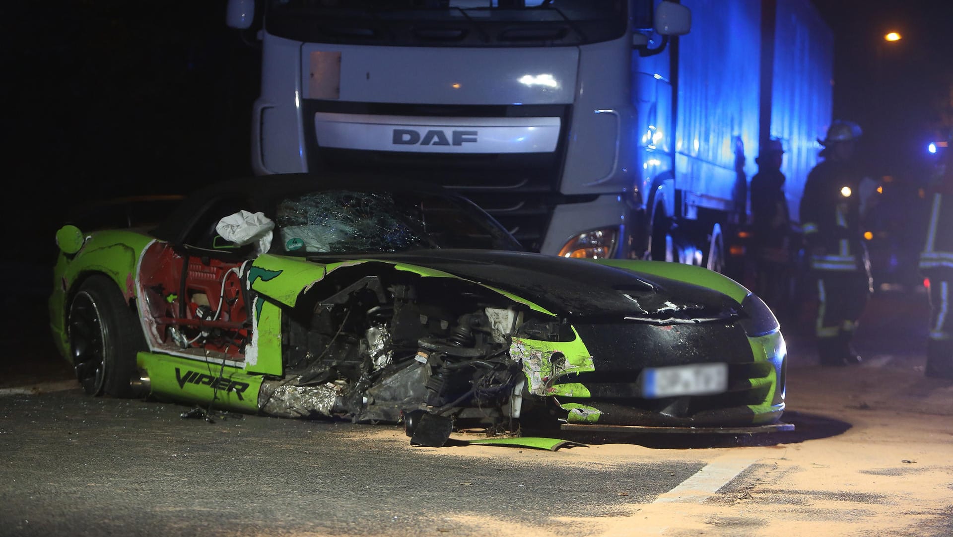 Der zerstörte Sportwagen steht in Düsseldorf vor einem Lastwagen.