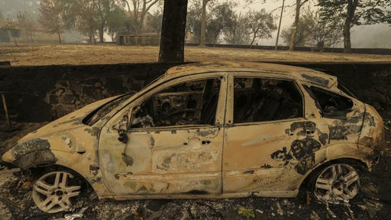 Ein ausgebranntes Auto steht in der Nähe von Vouzela in Portugal auf einer Straße.