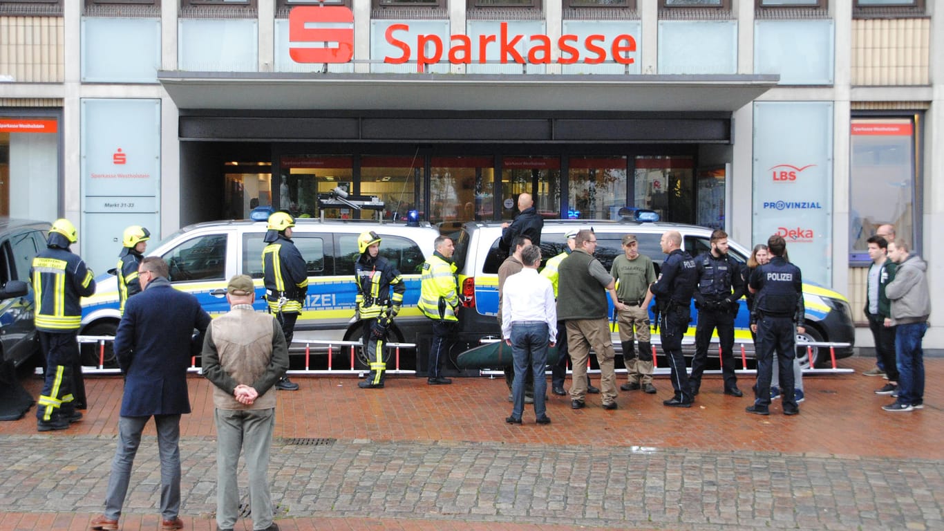 Einsatzkräfte der Polizei und Feuerwehr verbarrikadierten den Eingang einer Sparkassen-Filiale mit ihren Fahrzeugen, um die Wildschweine einzukesseln.