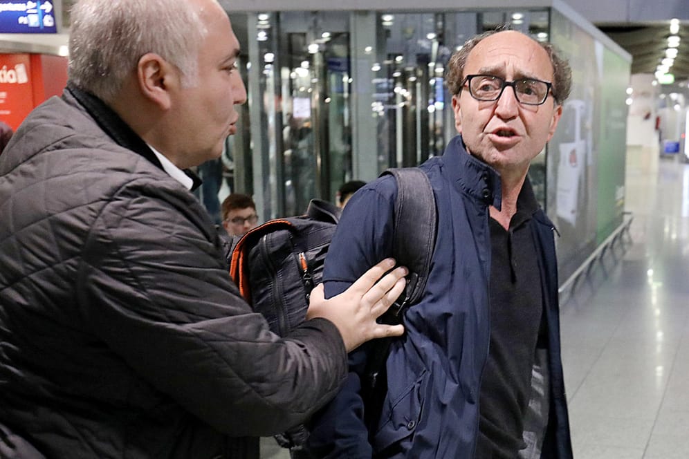 Dogan Akhanli wird in Düsseldorf auf dem Flughafen von seinem Anwalt Illias Uyar festgehalten, nachdem er auf Türkisch beschimpft wurde.