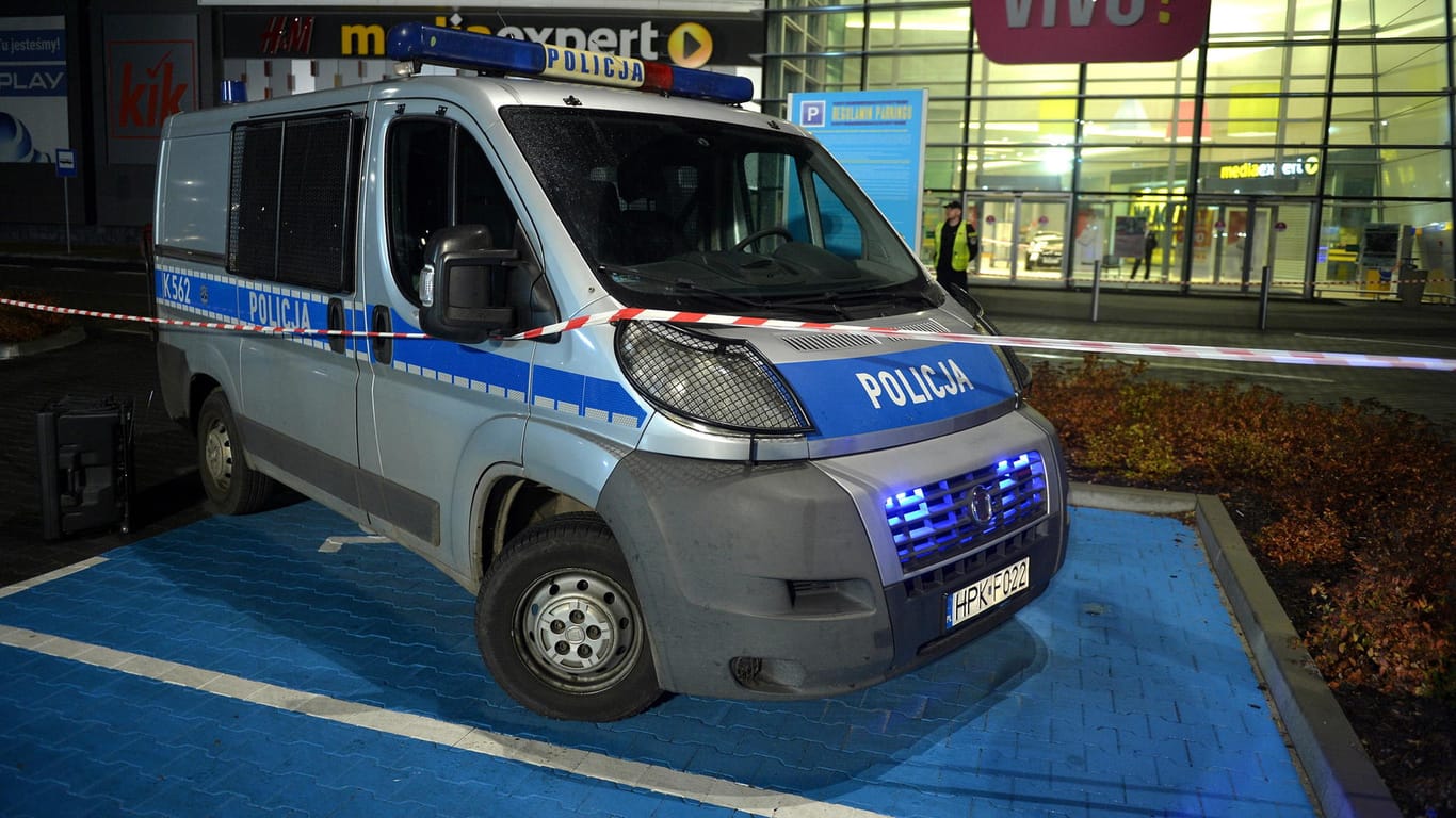 Ein Polizeifahrzeug steht vor dem Tatort an dem Einkaufszentrum in Stalowa Wola.