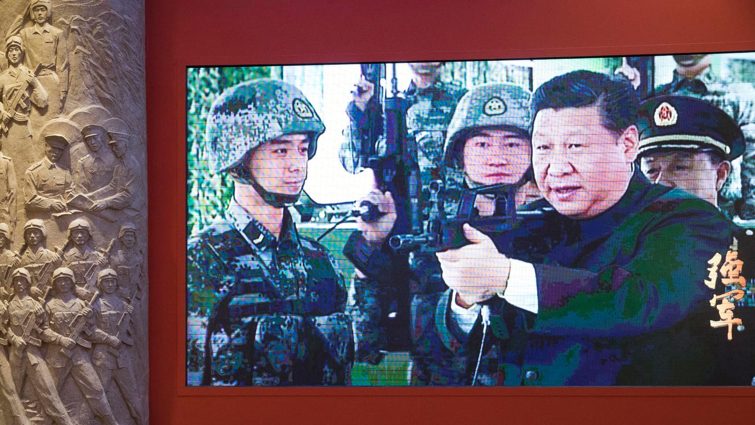 Chinas Präsident Xi ist bei einer Ausstellung in einem Video mit einem Sturmgewehr und Soldaten zu sehen. Chinas Präsident Xi ist bei einer Ausstellung in einem Video mit einem Sturmgewehr und Soldaten zu sehen.
