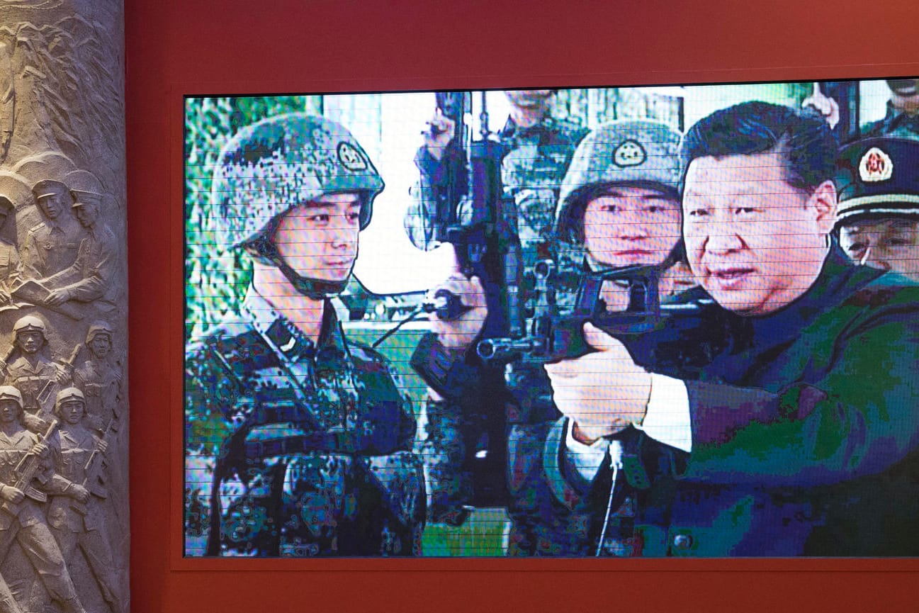 Chinas Präsident Xi ist bei einer Ausstellung in einem Video mit einem Sturmgewehr und Soldaten zu sehen.