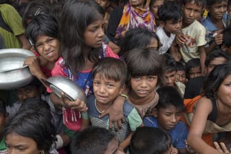 Kinder der Volksgruppe der Rohingya warten in einem Flüchtlingslager in Thaingkhali (Bangladesch) auf Essensrationen.