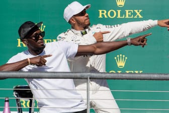 Lewis Hamilton (r.) und Sprint-Legende Usain Bolt auf dem Siegerpodest.