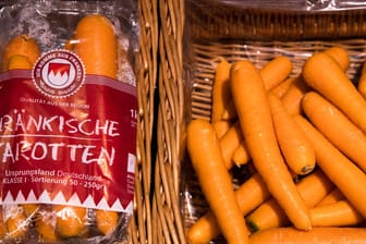 In Plastik verpackte Karotten liegen neben losen Karotten zum Verkauf