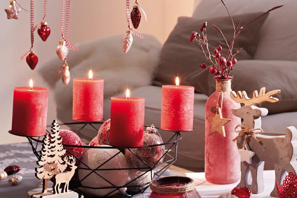 Weihnachtliche Dekoration mit Adventskranz, roten Beeren und Holzrentier
