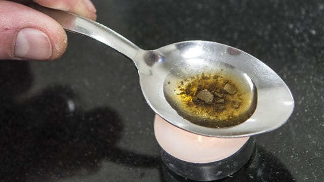 Ein Mann "kocht" sich auf einem Löffel die Dosis für einen Schuss Heroin. Ein Mann "kocht" sich auf einem Löffel die Dosis für einen Schuss Heroin.