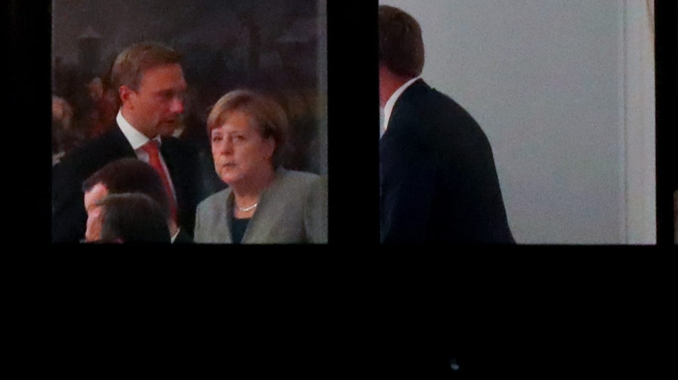 Kanzlerin Angela Merkel spricht mit FDP-Chef Christian zu Beginn der Sondierungsrunde in der Parlamentarischen Gesellschaft in Berlin.