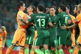 Rudelbildung: Die Werder-Spieler legen sich mit Hoffenheims Benjamin Hübner (l.) an.