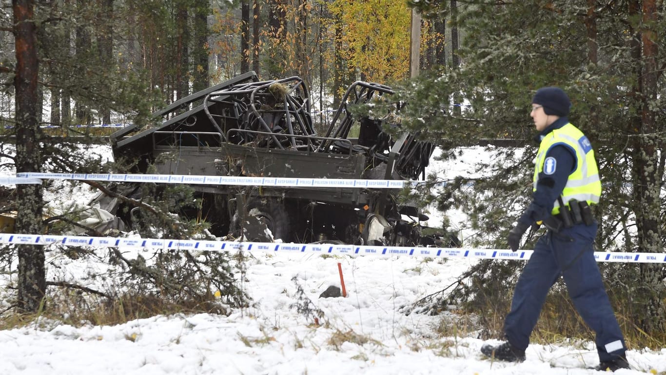 Ein Polizist geht an dem beschädigten Militärfahrzeug vorbei. Ein Personenzug kollidierte mit einem mit Soldaten besetzten Fahrzeug in Finnland.