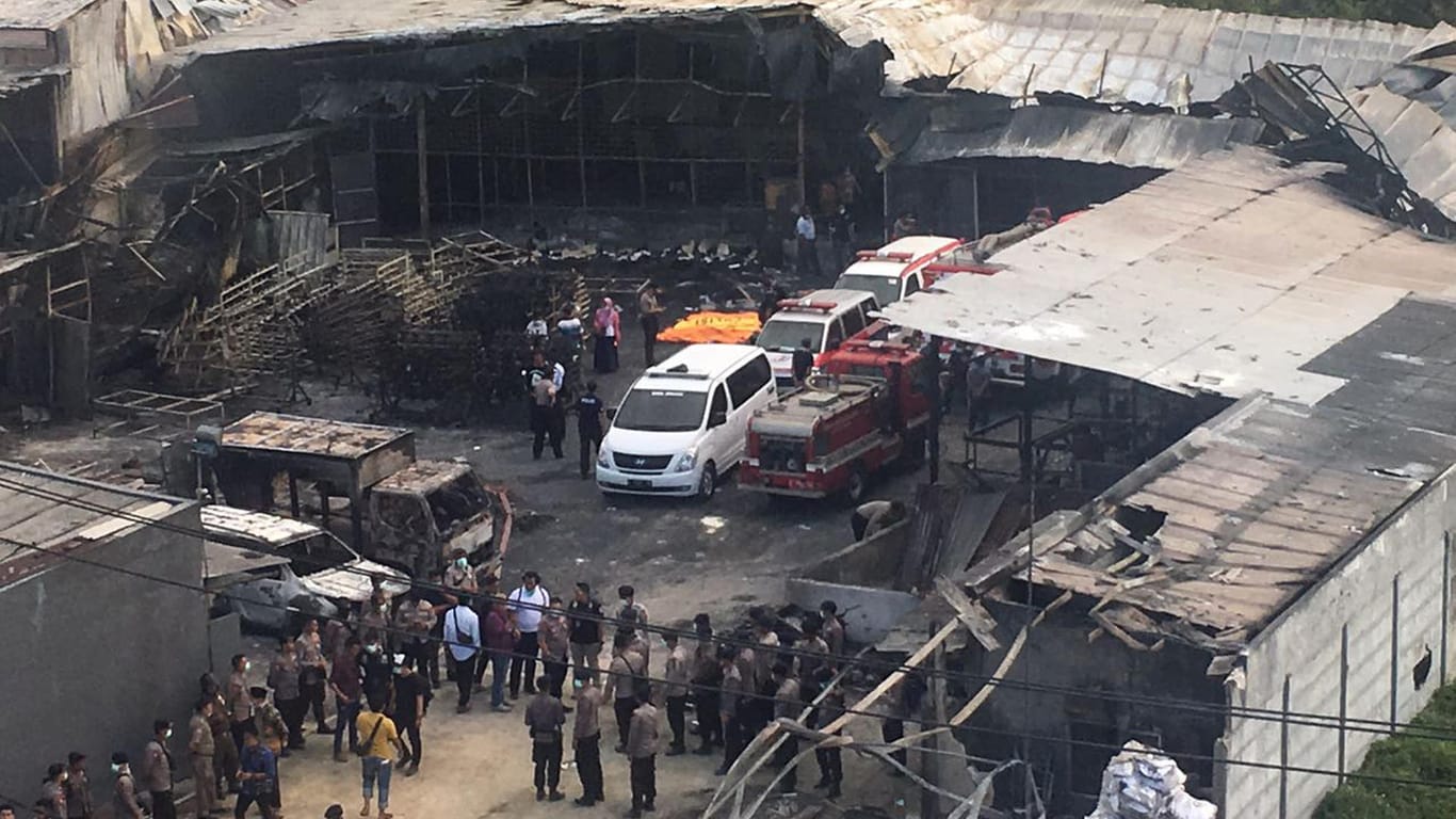 Polizisten und Rettungskräfte untersuchen die zerstörte Feuerwerksfabrik