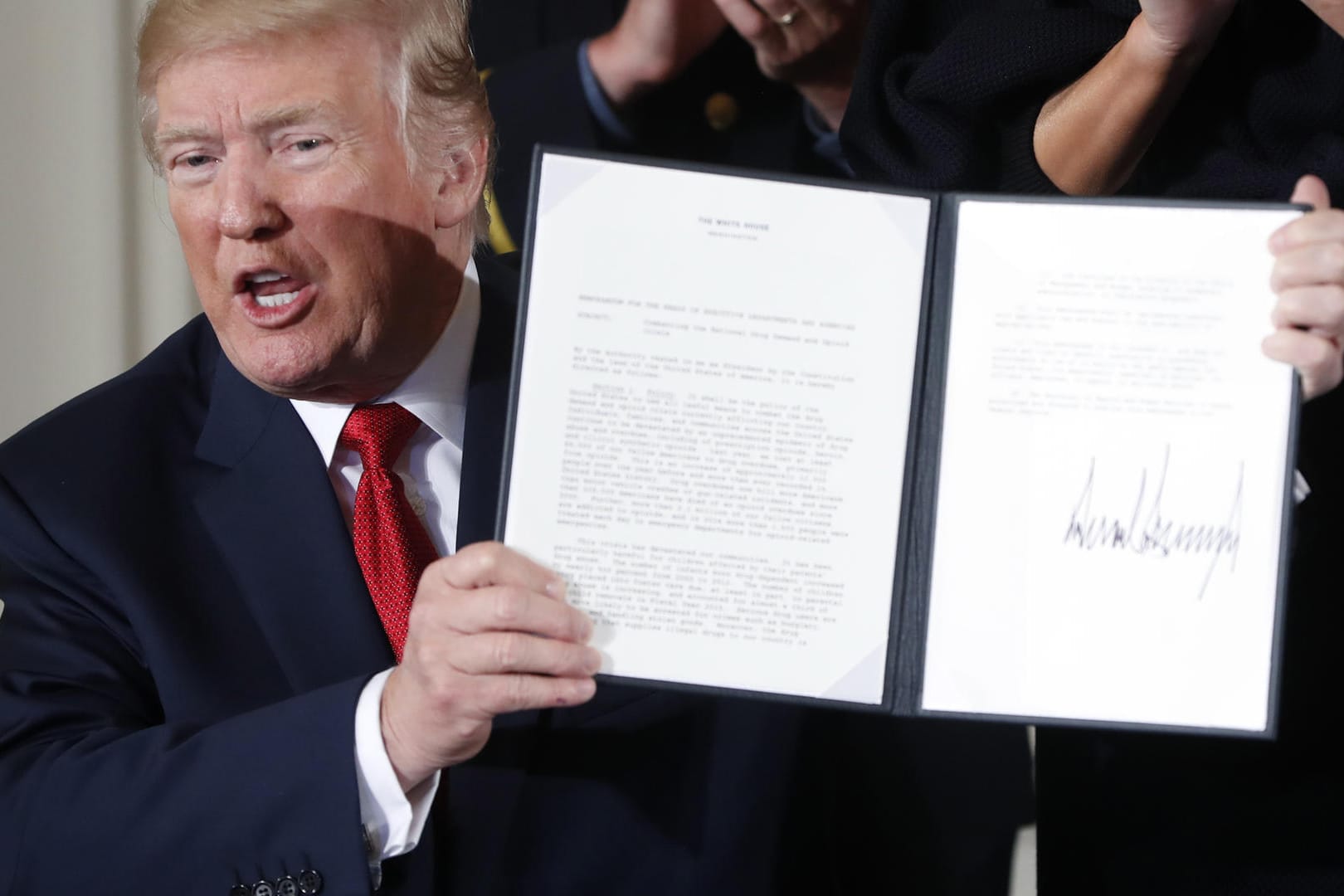 US-Präsident Donald Trump zeigt auf einer Pressekonferenz im Weißen Haus das Memorandum, in dem er den nationalen Gesundheitsnotstand erklärt.