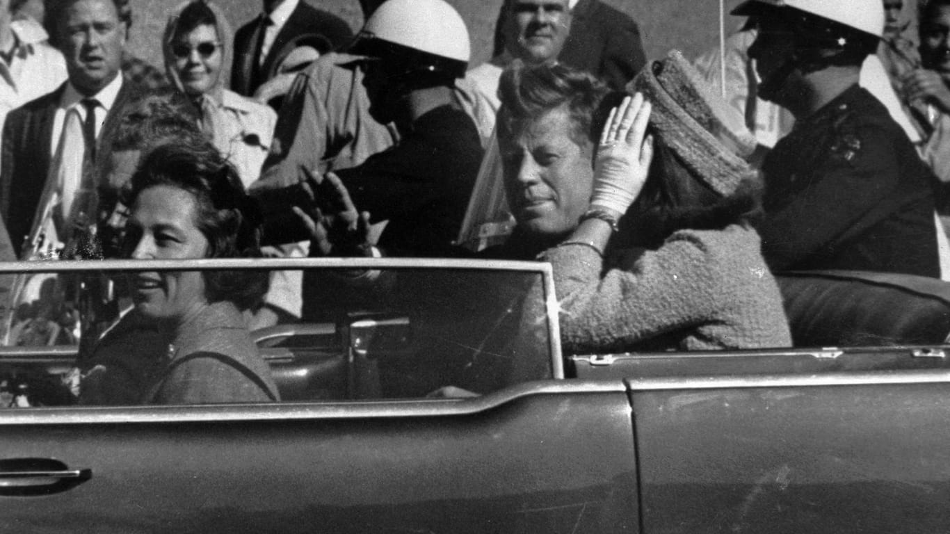 Kurz vor seiner Ermordung sitzt der damalige US-Präsident John F. Kennedy in Dallas zusammen mit seiner Frau Jacqueline (r), Nellie Connally (l) und ihrem Mann, dem Gouverneur von Texas, John Connally, in einer offenen Limousine.
