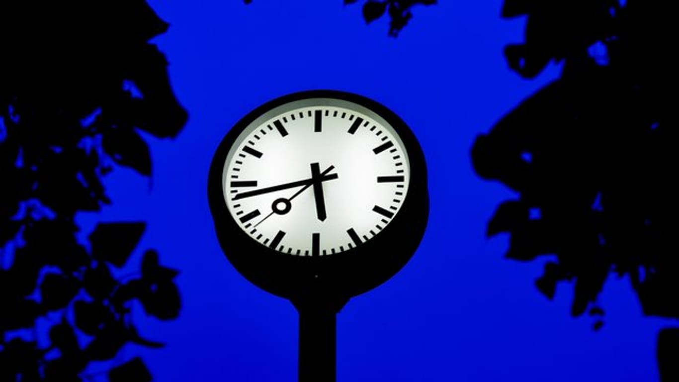 Eine Uhr steht zur blauen Stunde in Düsseldorf.