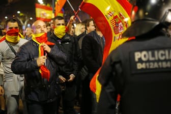 Gegner der Unabhängigkeit geraten in Barcelona mit Polizisten aneinander. Einige Demonstranten haben sich mit der spanischen Flagge vermummt.