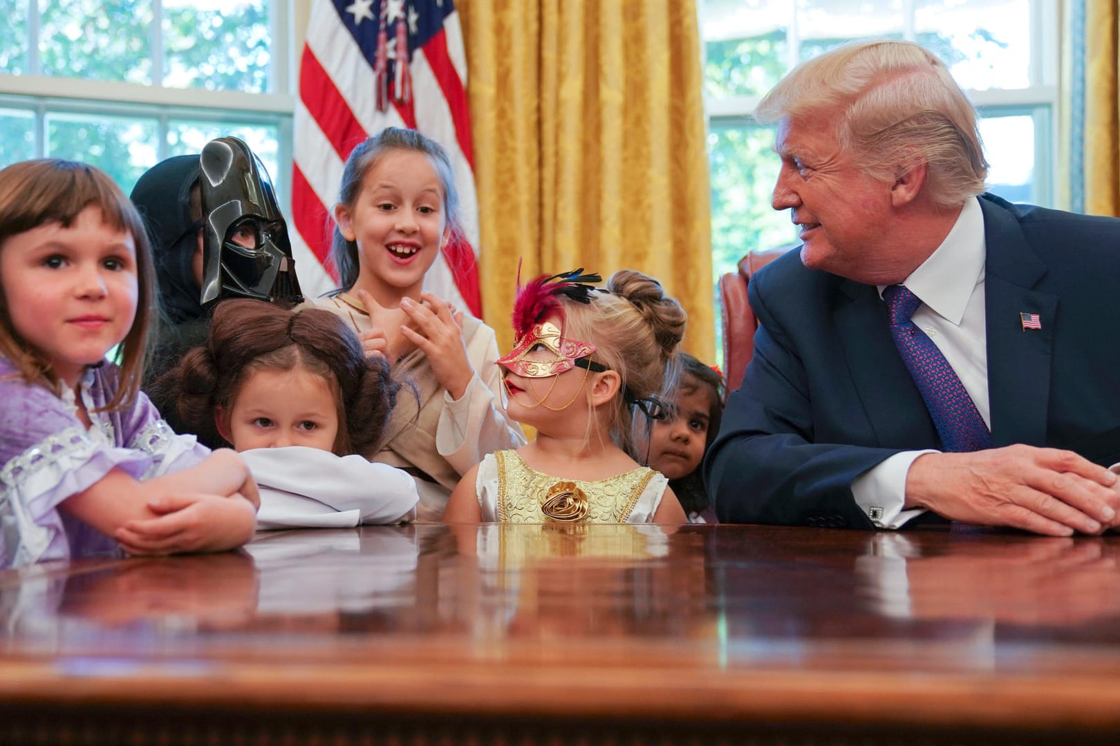 Donald Trump verteilt Schokolade an Kinder.