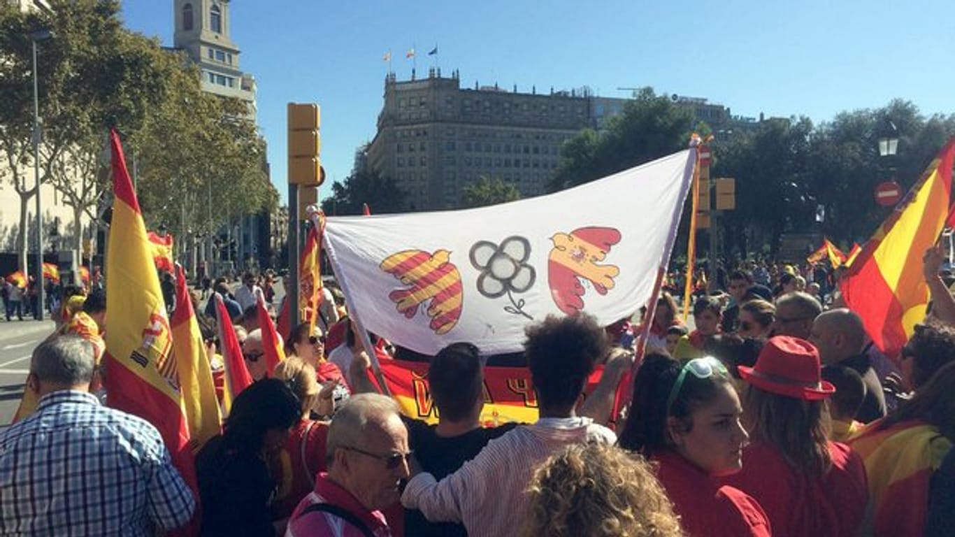 Demonstranten halten in Barcelona ein Banner mit Friedenstauben in den Farben der katalanischen und der spanischen Flaggen.