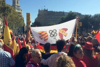 Demonstranten halten in Barcelona ein Banner mit Friedenstauben in den Farben der katalanischen und der spanischen Flaggen.