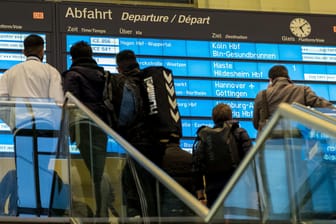 Zugreisende stehen warten in Hannover auf eine Verbindung.