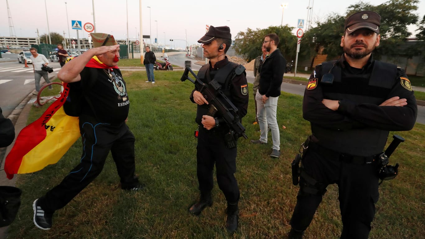 Ein Befürworter der spanischen Einheit salutiert vor spanischen Polizisten.